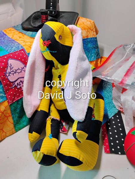 RABBIT B made with yellow and black material sewn together. Ears and tail made from Minky fabric. Wood joints installed for posing only. This is not a toy for children.