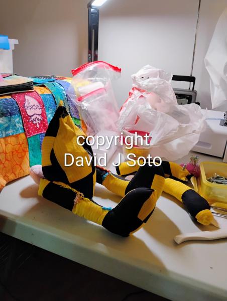 RABBIT B made with yellow and black material sewn together. Ears and tail made from Minky fabric. Wood joints installed for posing only. This is not a toy for children.