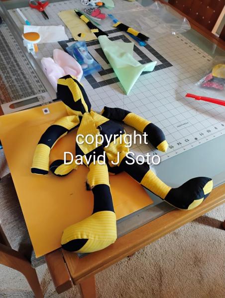 RABBIT B made with yellow and black material sewn together. Ears and tail made from Minky fabric. Wood joints installed for posing only. This is not a toy for children.